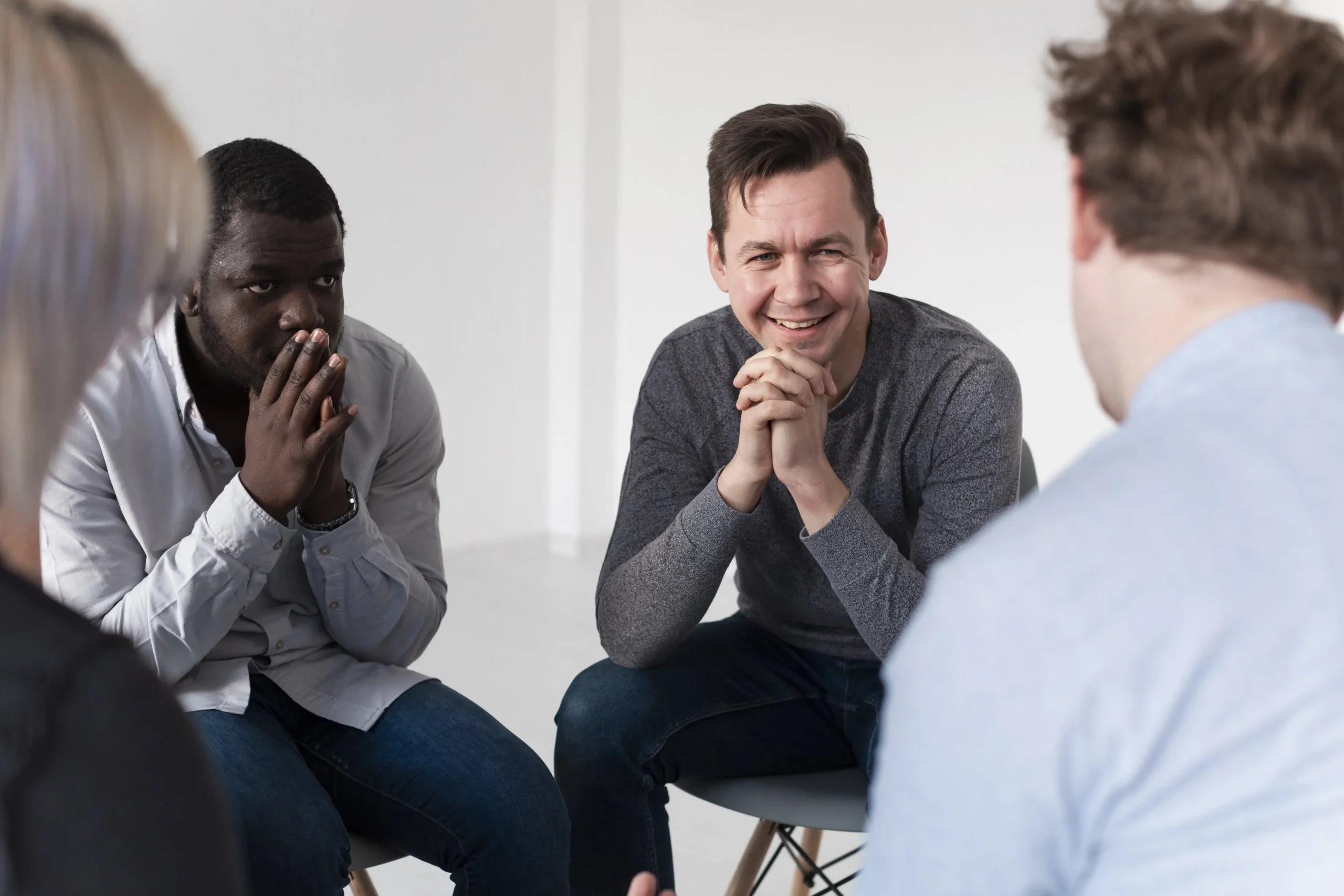 smiling male talking with others in a therapy session