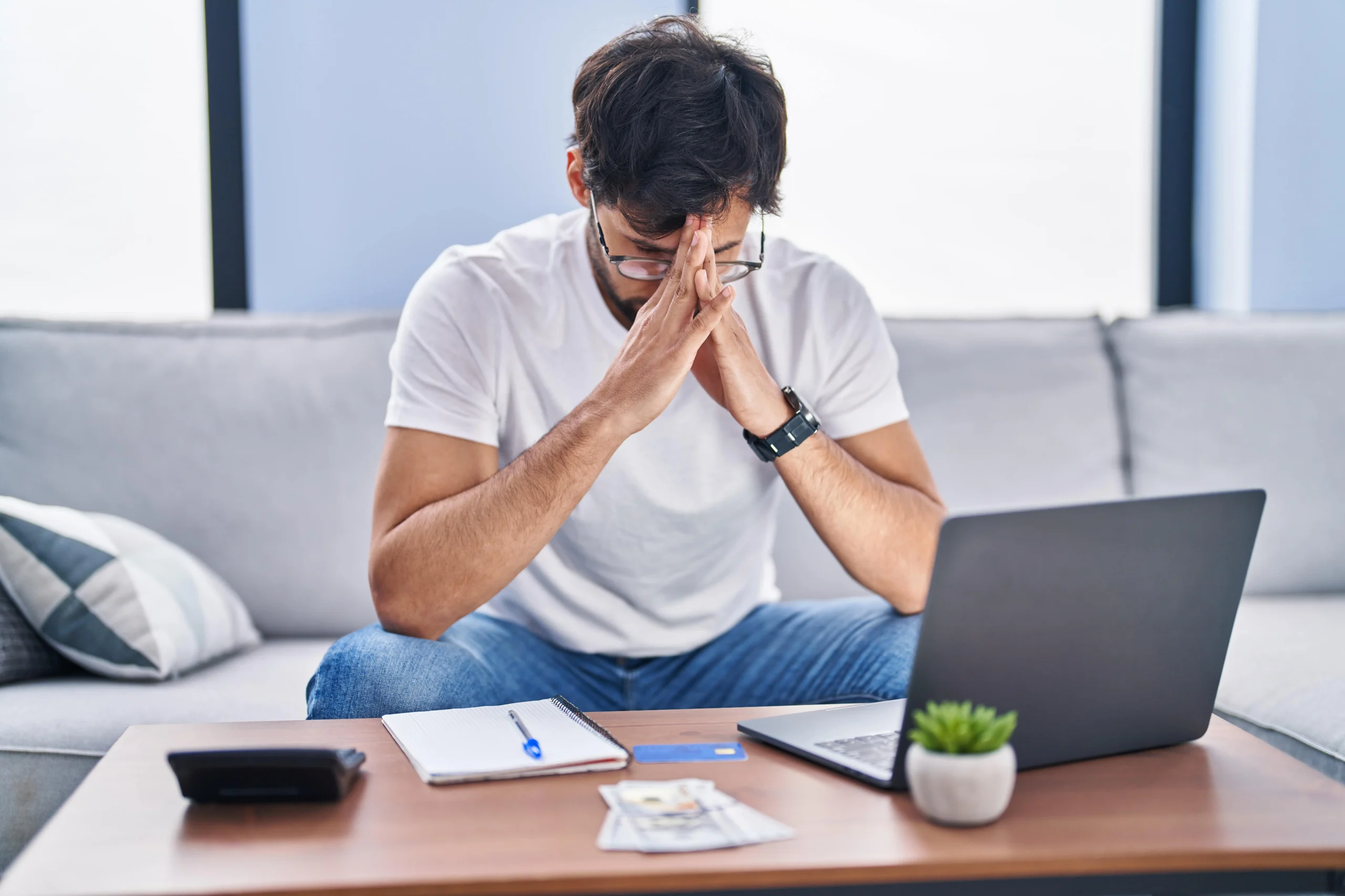 Young man stressed using Laptop working at home